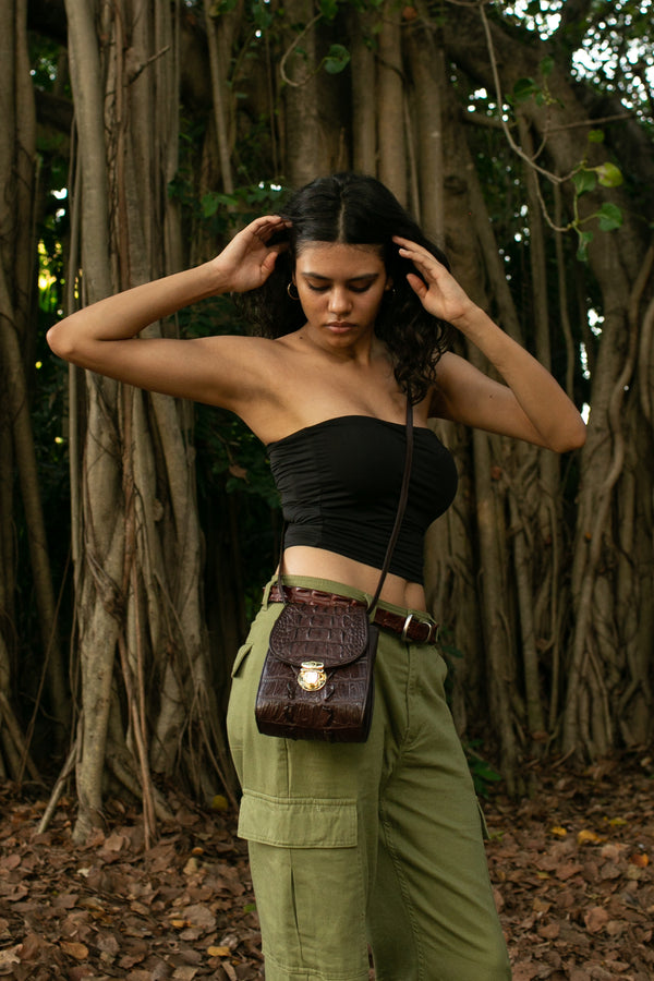 a girl showing her crocodile skin handbag which is called Bella